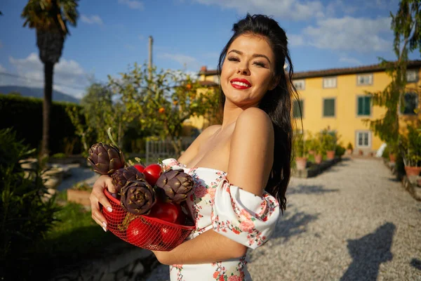 一个女人把一篮子蔬菜放在花园外面 意大利人的生活方式 — 图库照片