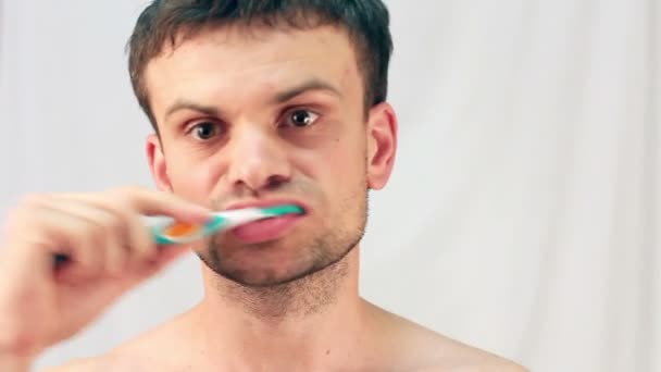 Молодий чоловік чистить зуби — стокове відео