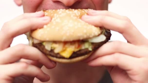 Az ember eszik egy hamburgert — Stock videók