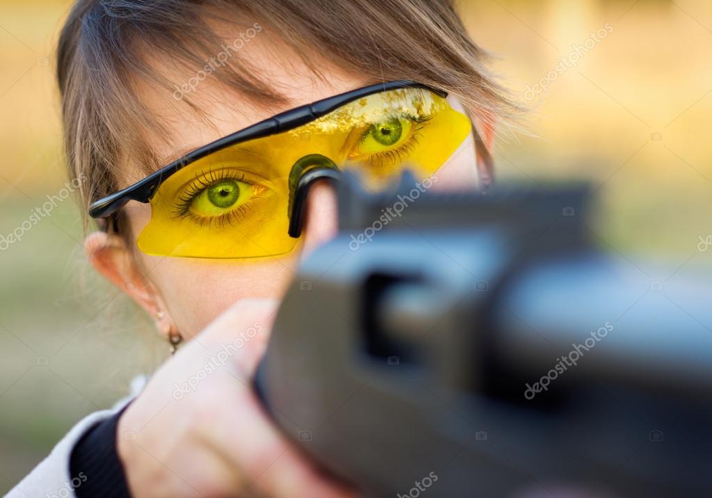 A young girl with a gun for trap shooting and shooting glasses — Stock