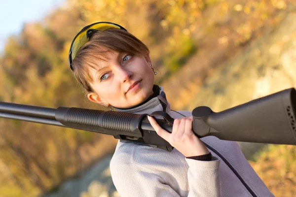 Young beautiful girl with a shotgun — Stock Photo, Image