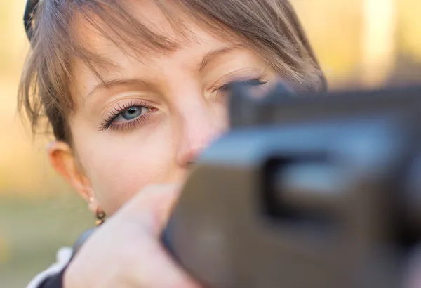 Girl with a gun for trap shooting and shooting glasses aiming at — Stock Photo, Image