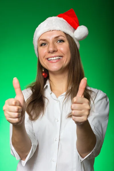 Girl in a Christmas hat on a green background — Stock Photo, Image
