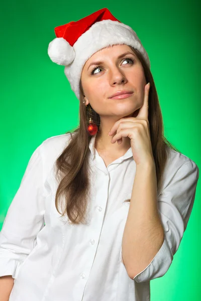 Girl in a Christmas hat on a green background — Stock Photo, Image