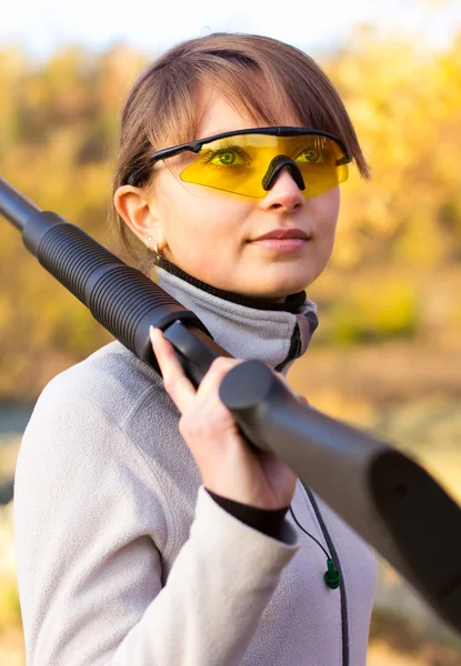 Young beautiful girl with a shotgun — Stock Photo, Image