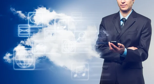 Businessman with touch screen phone and the cloud with icons — Stock Photo, Image