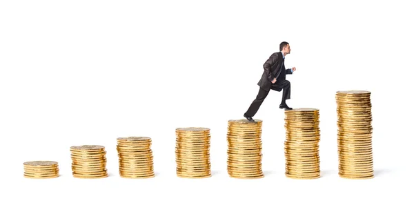 Businessman goes up the gold coins — Stock Photo, Image
