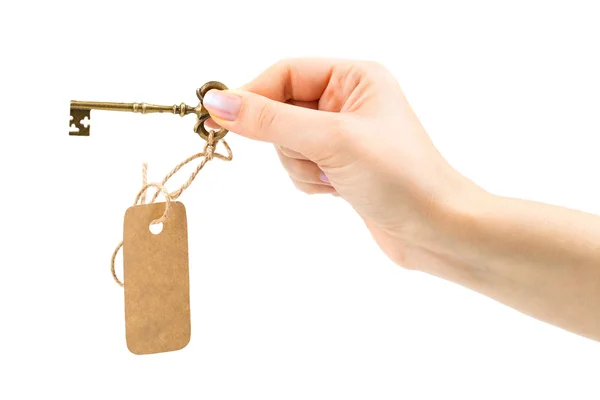 Vintage key with a tag in a female hand — Stock Photo, Image