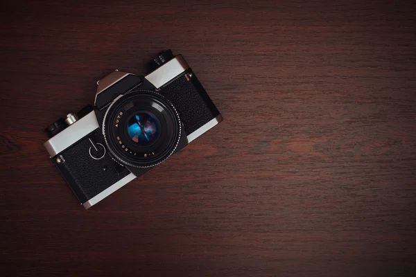 Old film camera on a wooden table — Stock Photo, Image