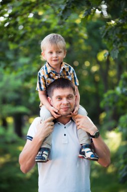 Baba ve bebek oğlu açık parkta eğleniyor