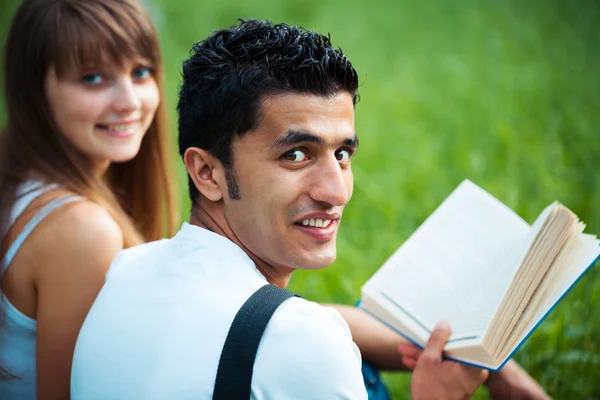 Два студента учатся в парке на траве — стоковое фото