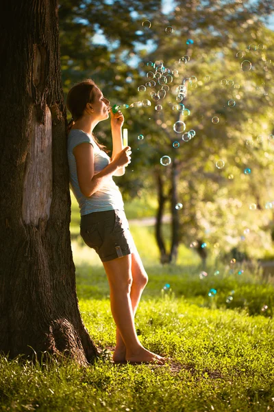 A girl blows bubbles — Stock Photo, Image