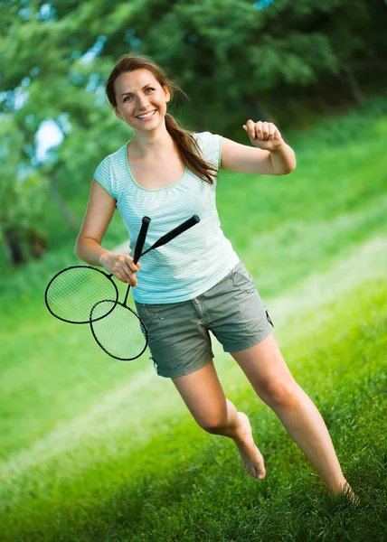 Leende flicka med ett racket för en badminton i parken — Stockfoto