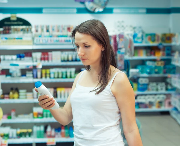 Jovem mulher fazendo compras na loja de produtos químicos domésticos e cosmet — Fotografia de Stock