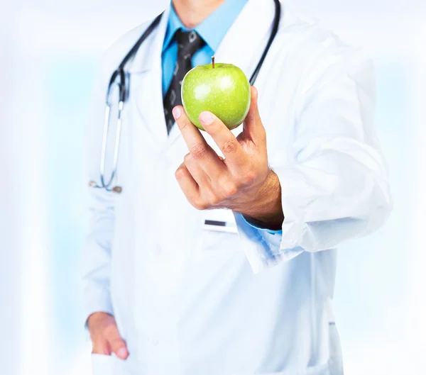 Mano del doctor sosteniendo un primer plano de manzana verde fresca — Foto de Stock