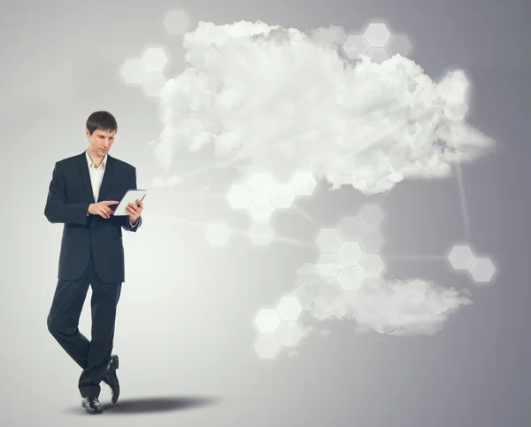 Businessman with touchscreen internet tablet and the clouds — Stock Photo, Image