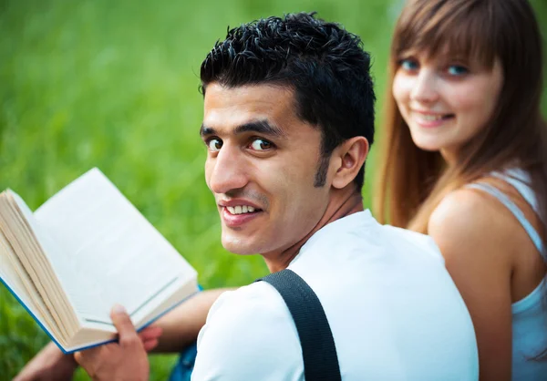 Två studenter kille och tjej som studerar i parken på gräs — Stockfoto