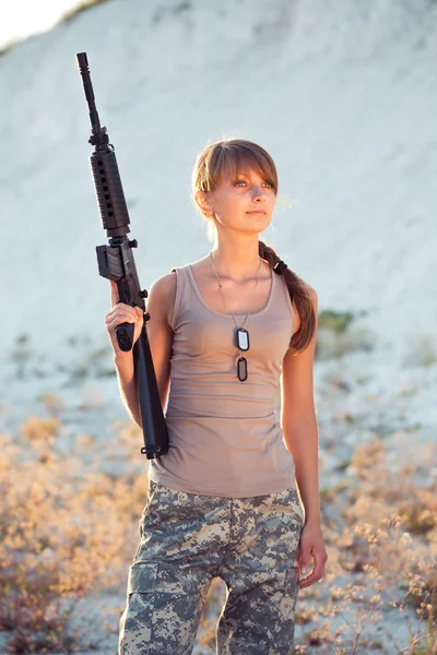 Jeune belle soldat femme vêtue d'un camouflage avec une ri — Photo