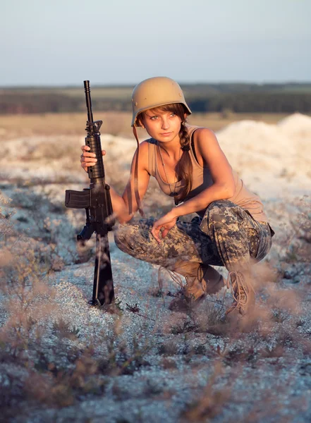 Soldado vestido com uma camuflagem com uma arma ao ar livre — Fotografia de Stock