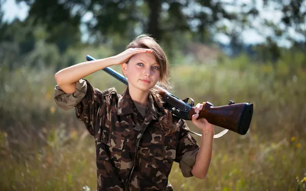 Junge schöne Mädchen mit einer Schrotflinte im Freien — Stockfoto