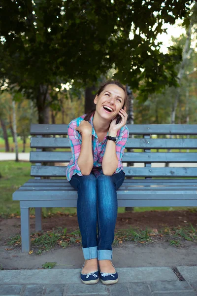 Un retrato de una hermosa mujer sonriente en el parque hablando en t —  Fotos de Stock