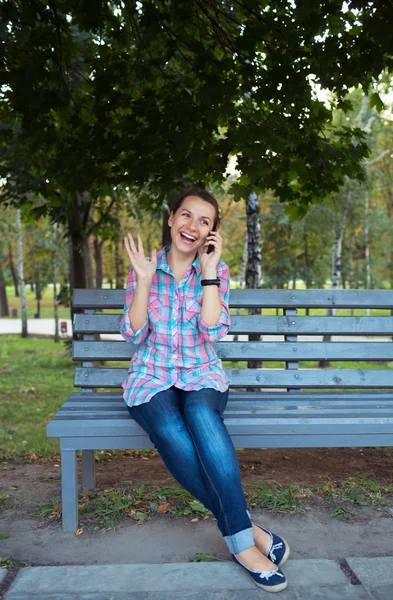 Портрет улыбающейся красивой женщины в парке, говорящей на — стоковое фото