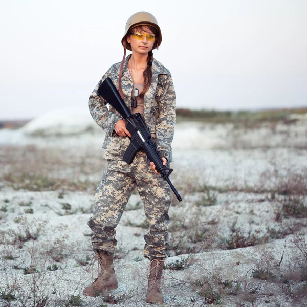 年轻的女士兵拿着枪在 o 穿着迷彩 — 图库照片