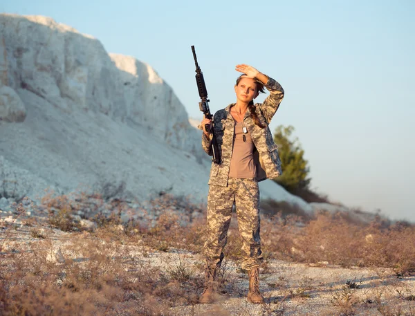 L bir silahla bir kamuflaj giyinmiş genç kadın asker — Stok fotoğraf