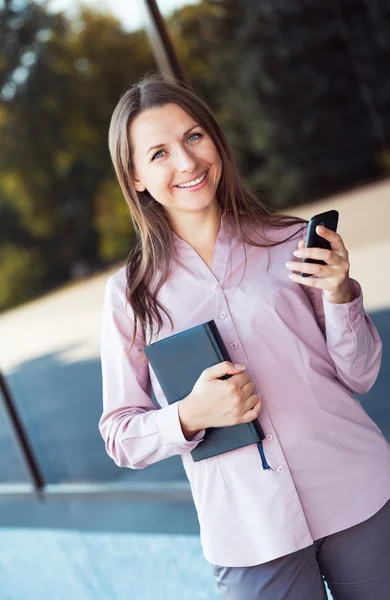 Mladá podnikatelka s mobil a organizátor — Stock fotografie