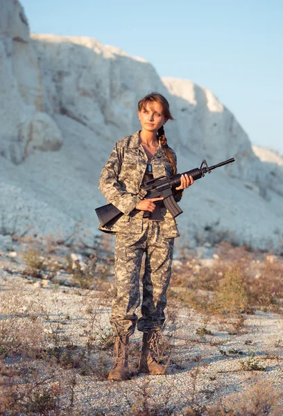 L bir silahla bir kamuflaj giyinmiş genç kadın asker — Stok fotoğraf