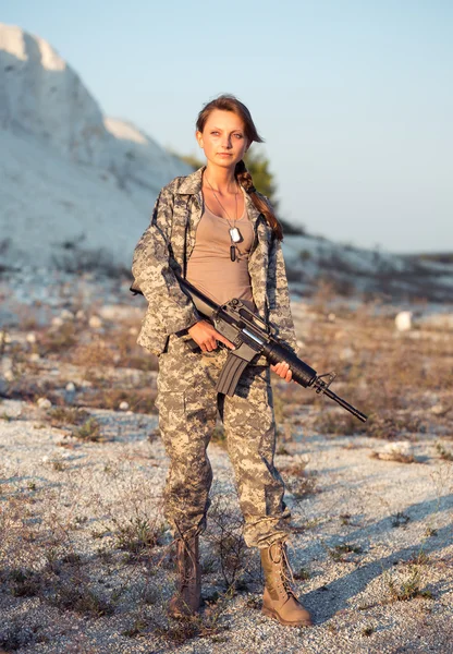 L bir silahla bir kamuflaj giyinmiş genç kadın asker — Stok fotoğraf
