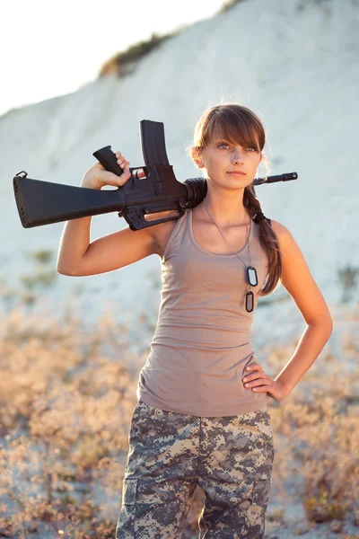 Giovane soldato donna vestita con un camuffamento con una pistola in o — Foto Stock