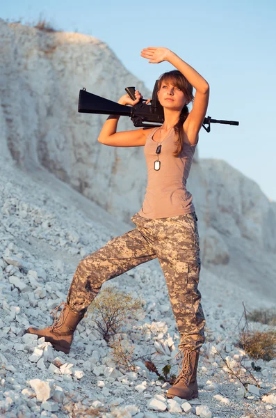Joven soldado vestida con un camuflaje con un arma en la l — Foto de Stock