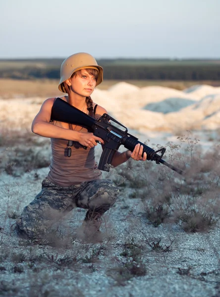 Mladá žena voják oblečený v maskování s pistolí v o — Stock fotografie