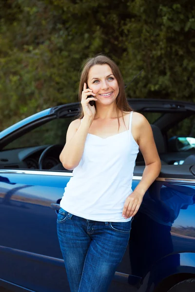 Lächelnde Frau telefoniert im Cabrio — Stockfoto
