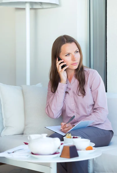 Businesswoman talking on the phone in a coffee shop — Stock Photo, Image