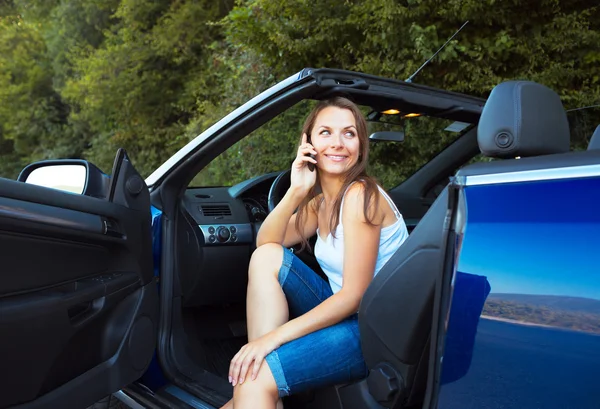 Sonriente mujer caucásica hablando por teléfono en un cabriolet — Foto de Stock