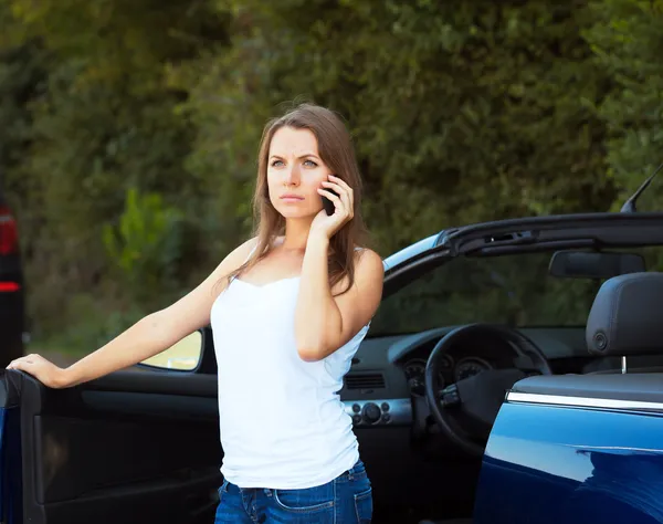 Caucasian girl on a cell phone service or tow truck traffic near Stock Image