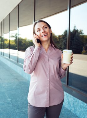 cep telefonu ve kahve ayakta aga ise genç iş kadını