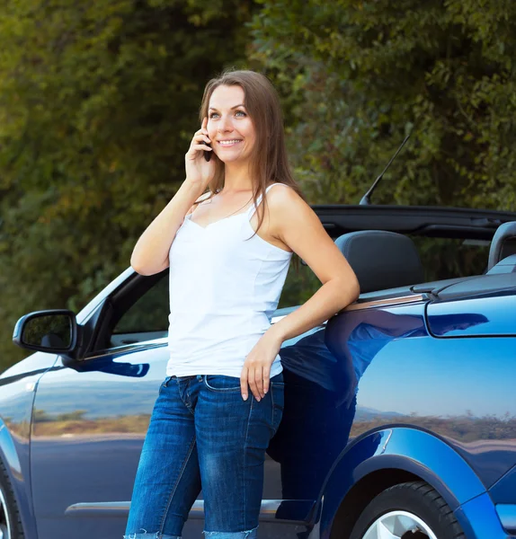 Sorrindo mulher caucasiana falando ao telefone em um cabriolet — Fotografia de Stock