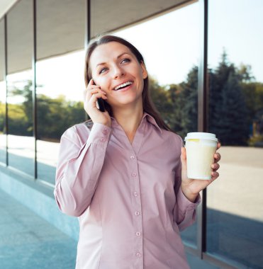 cep telefonu ve kahve ayakta aga ise genç iş kadını