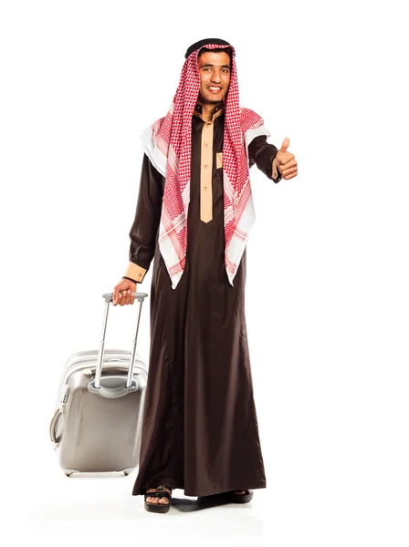 Joven árabe sonriente con una maleta y el pulgar hacia arriba aislado en whit — Foto de Stock