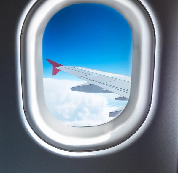 Fenêtre de l'avion qui vole au-dessus des nuages — Photo