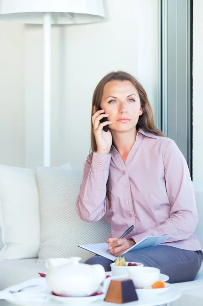 Businesswoman talking on the cellphone in a coffee house — Stock Photo, Image