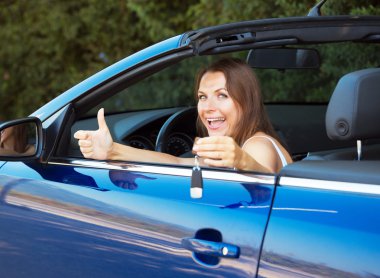gülümseyen bir cabriolet anahtarı gösterilen beyaz kadın