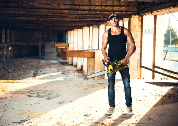 Man with a chainsaw on the ruins — Stock Photo, Image