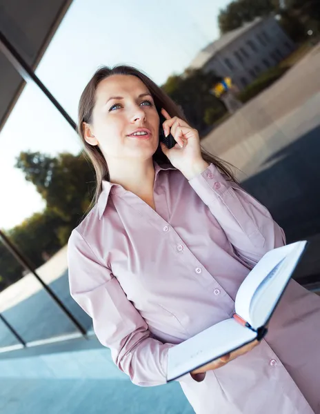 Young businesswoman with cellphone and organizer while standing — Stock Photo, Image