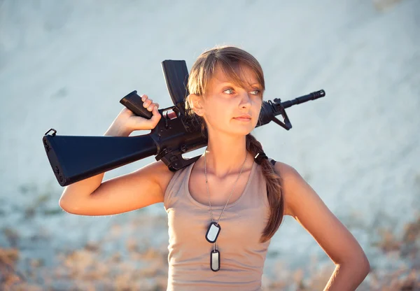 Giovane soldato donna vestita con un camuffamento con una pistola in o — Foto Stock