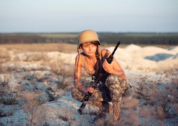 Νεαρού στρατιώτη γυναίκα ντυμένη με ένα καμουφλάζ με ένα πυροβόλο όπλο στο o — Φωτογραφία Αρχείου