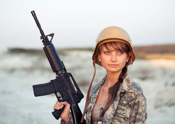 Joven soldado vestida con un camuflaje con un arma en el —  Fotos de Stock